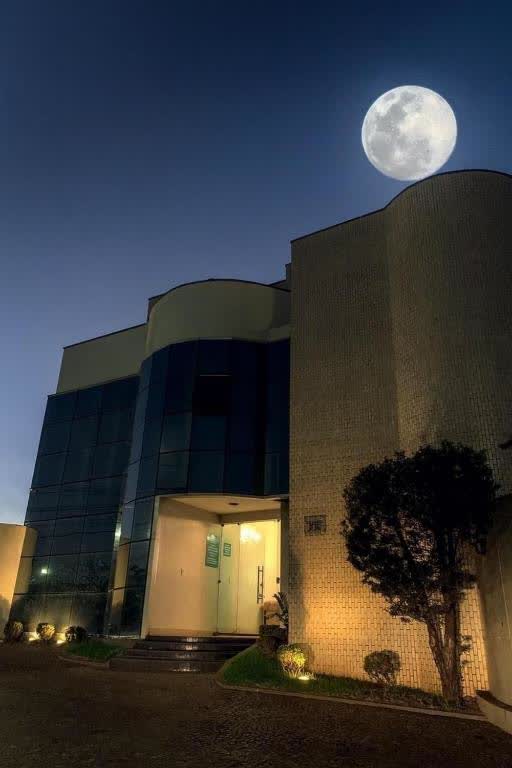 Oásis Hotel building at night with a full moon